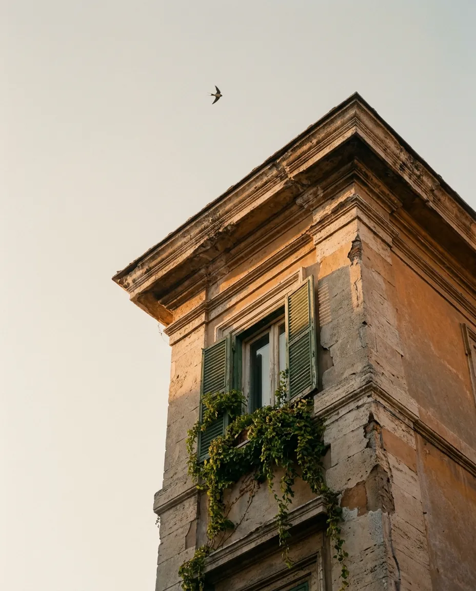 A glimpse of a Roman cornice and shutters in the afternoon light