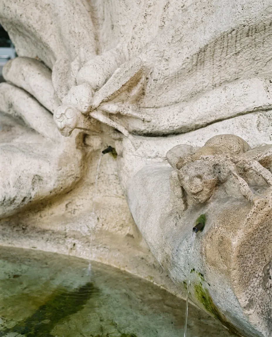 Close-up of the three travertine bees on the Fountain of the Bees, water falling from them